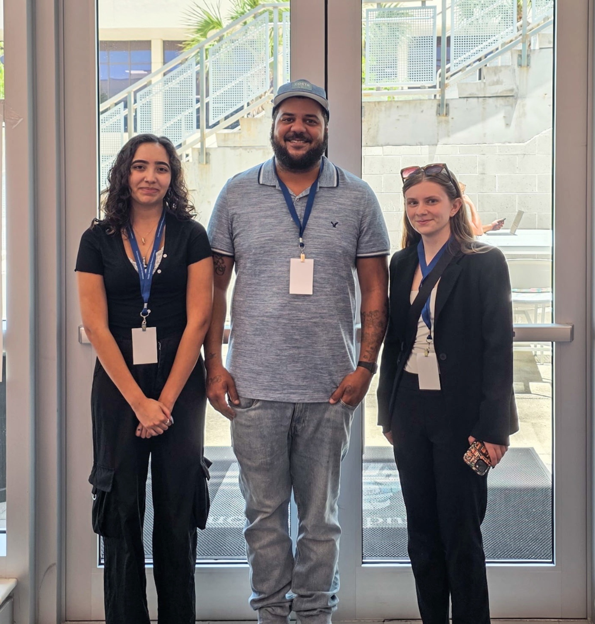 Three student winners standing in front of a window